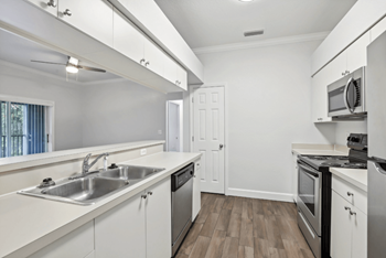 A kitchen with white cabinets and stainless steel appliances.